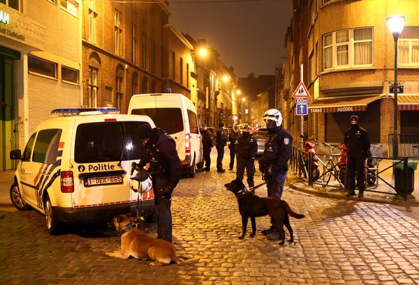 Police officers guard a road after the raid in which Salah Abdeslam was arrested.